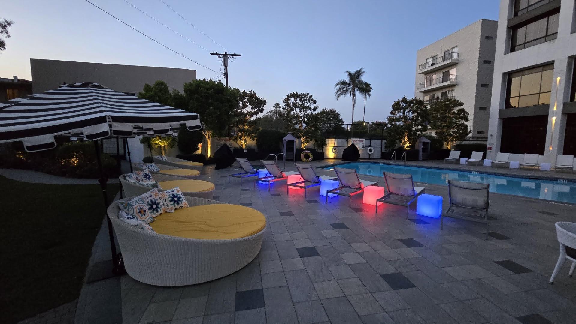 Outdoor pool deck with circular daybeds at twilight