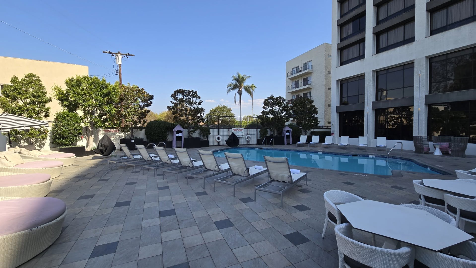 Outdoor swimming pool and sun loungers under blue skies