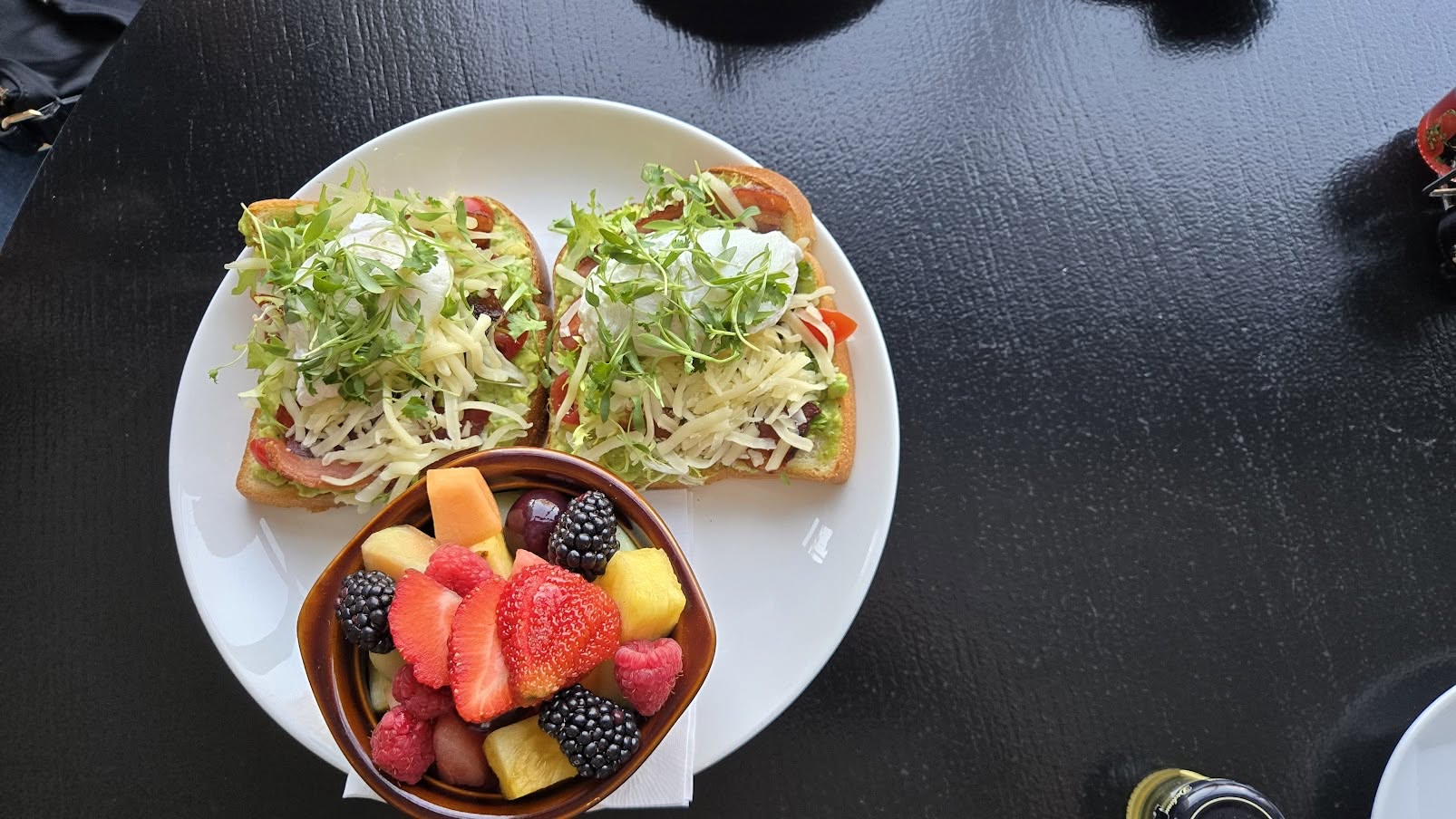 Artisan avocado toast with poached eggs and fresh fruit bowl