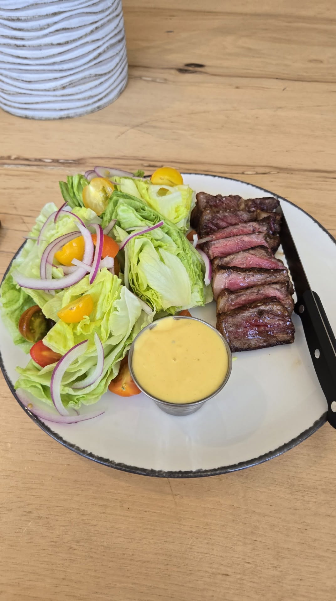 Sliced grilled ribeye steak with crisp iceberg wedge salad