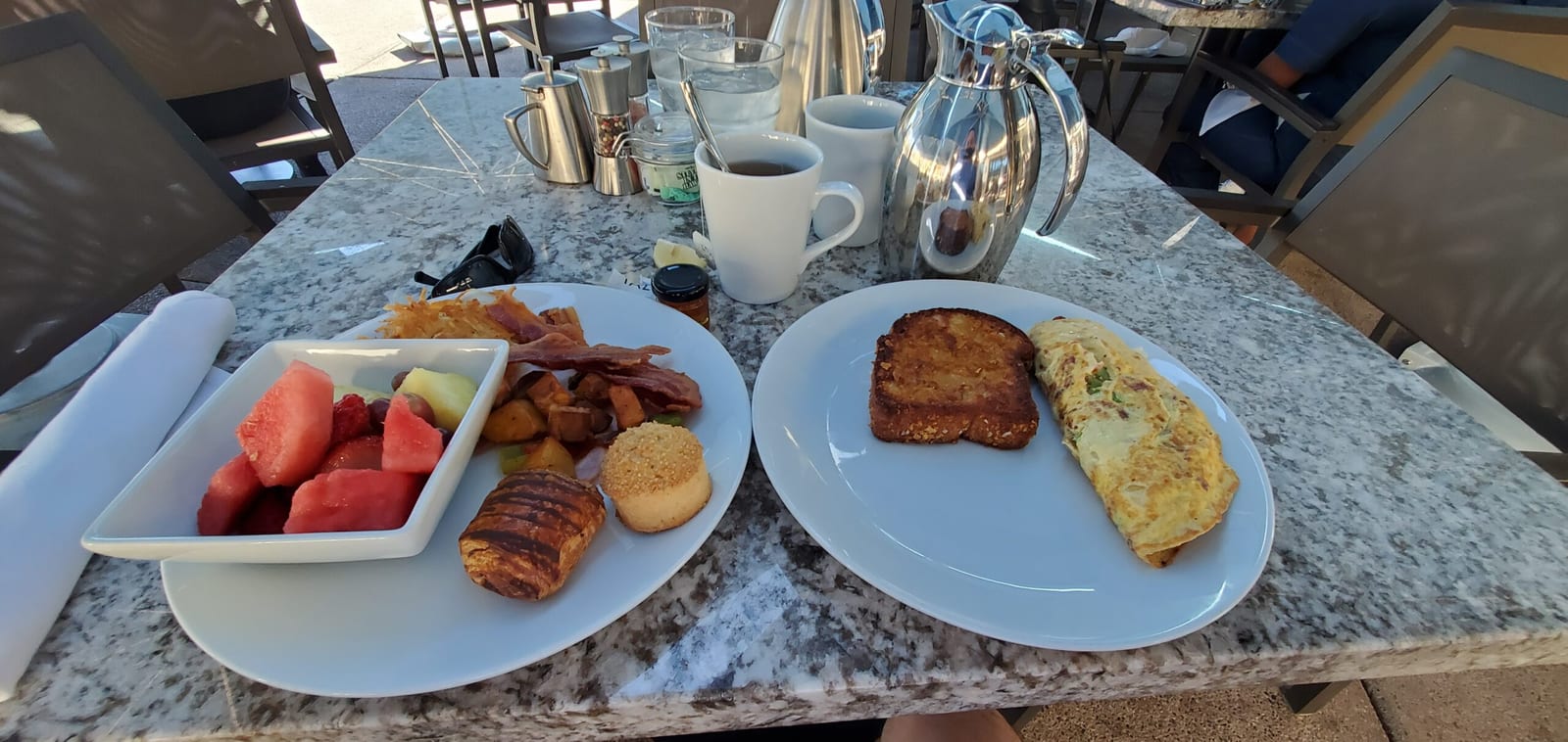Breakfast on the terrace featuring a custom omelet, fresh melon, pastries, and thermal coffee service. Scenic patio breakfast spread at Rita's with custom omelet, fresh fruit, and pastries