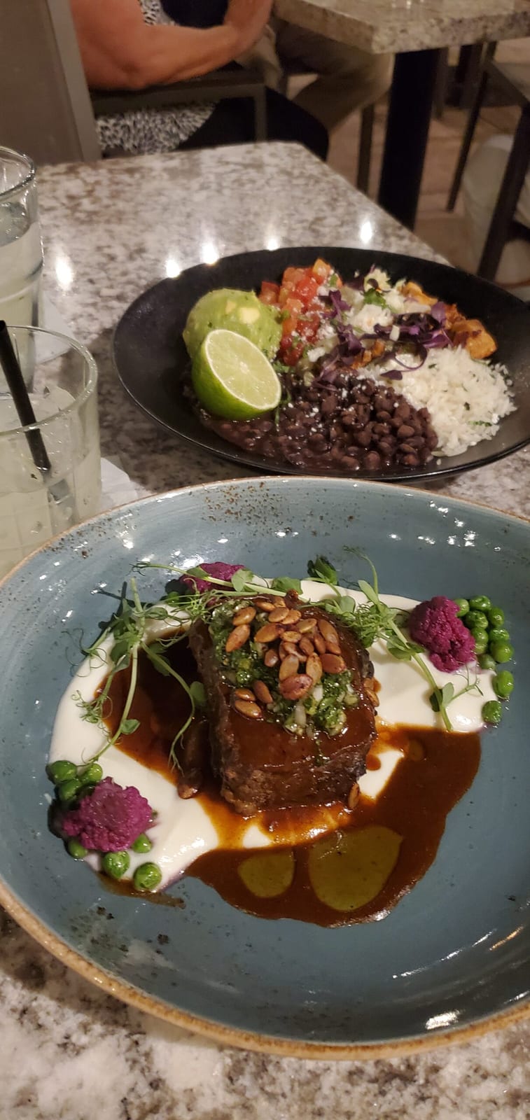 Braised beef short rib with pepitas and puree alongside a loaded Sonoran rice and black bean bowl. Braised beef short rib and Sonoran rice bowl at Rita's Cantina