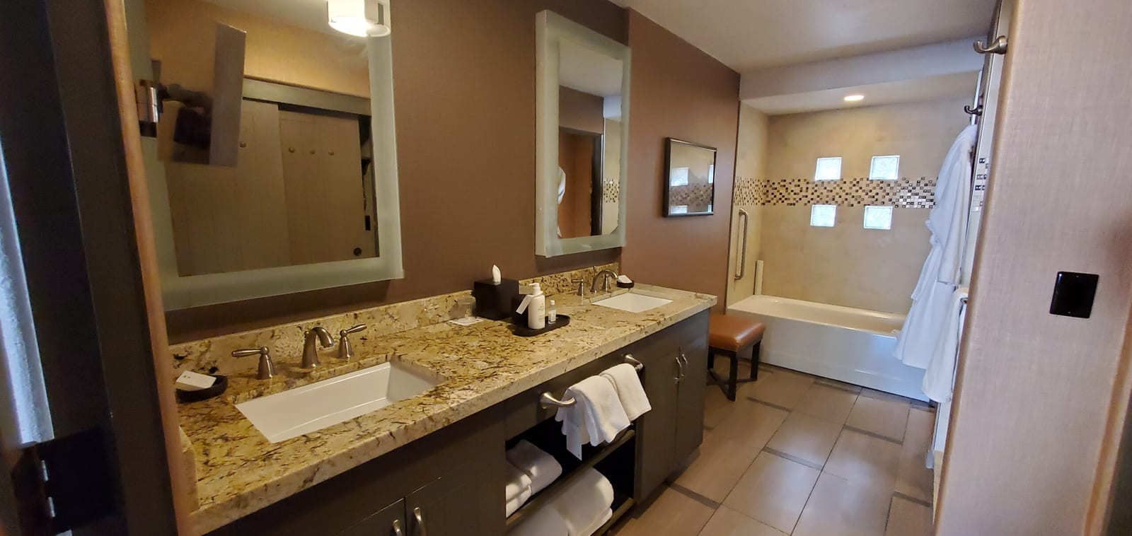 Spacious master bath featuring twin granite vanities and dual bronze faucets. Dual granite vanities in the casita bathroom suite